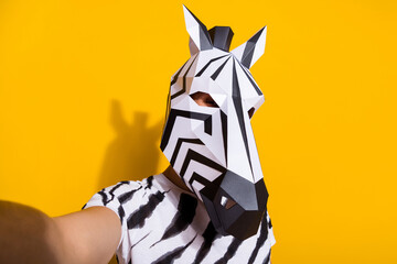 Portrait of bizarre surreal guy in zebra mask make selfie video call theme festival isolated over yellow color background