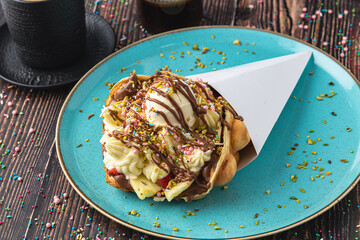 Hong kong or bubble waffle with ice cream, fruits, chocolate sauce and colorful candy