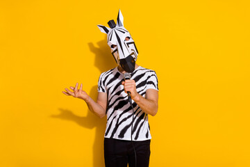 Photo of comedian guy in zebra costume present theme halloween event talk mic isolated over yellow...