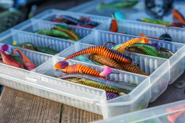 Fishing tackles and fishing baits in box .Classic Colored Fishing Lure , Beautiful Background digital image.Fishing on the lake at sunset.