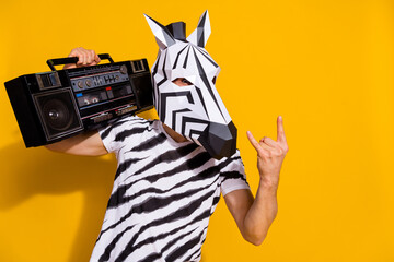 Photo of weird freak guy dj in zebra mask hold boom box song show horned fingers isolated over bright yellow color background