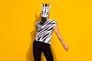 Photo of positive crazy man wear zebra print t-shirt mask dancing halloween event isolated yellow color background