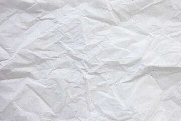 Crumpled white with color dots paper for gift wrapping or packaging. Closeup, texture background, pollution and recycling concept