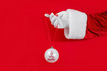 Christmas lettering of a white ball in Santa's hand, Christmas concept, brand.