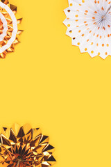Golden paper fans on a yellow background with place for text. Festive concept.