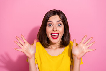 Photo of impressed funky young lady dressed yellow clothes smiling rising arms open mouth isolated pink color background