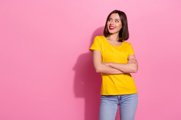 Photo of dreamy confident young woman wear yellow outfit looking empty space arms crossed smiling isolated pink color background