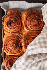 Freshly baked homemade cinnamon rolls or cinnabon on a baking sheet. Cinnabons traditional dessert buns pastry made swirl. Top view.