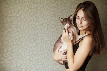 Happy Asian woman holding her cat. Fluffy cat, the cat on the hands. Beautiful young woman with cute cat resting at home
