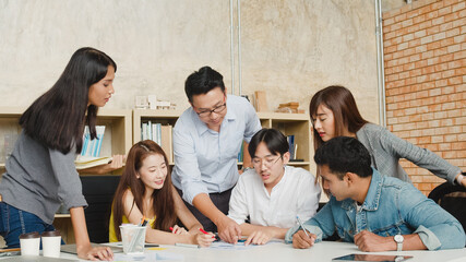 Multiracial group of young creative people in casual wear meeting brainstorming ideas about new paperwork project colleagues working together planning success strategy enjoy teamwork in small office