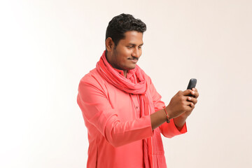 Young indian farmer using smartphone on white background.
