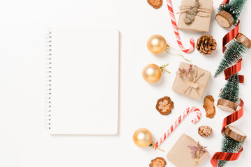 Fototapeta premium Minimal creative flat lay of winter christmas traditional composition and new year holiday season. Top view open mockup black notebook for text on white background. Mock up and copy space photography.