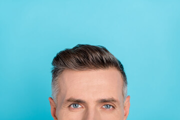 Cropped view portrait of attractive content man wearing modern haircut isolated over bright blue color background