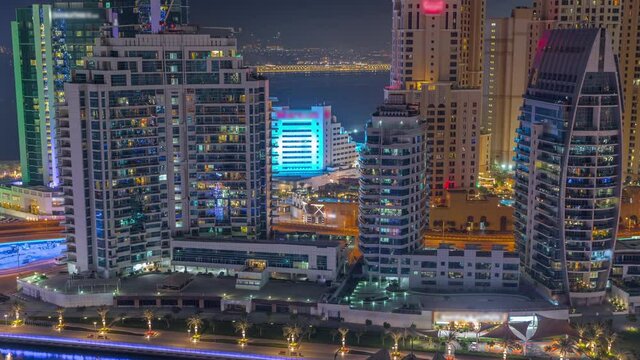 Dubai Marina skyscrapers and JBR district with luxury buildings and resorts aerial night timelapse