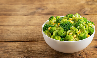 Bowl of broccoli salad on wooden background with copy space.