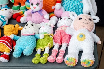 A collection of various knitted soft toys for a child on sale at the street market