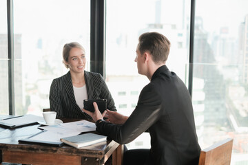 Two businessman and businesswoman couple meeting in co working space or office