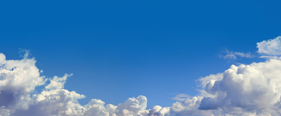 Blue sky with cumulus fluffy clouds.