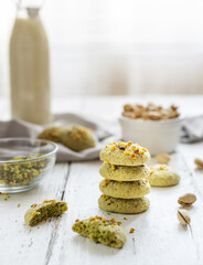 pistachios cookies and ingredients on the white wooden background