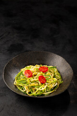 Zucchini spaghetti with tomatoes in garlic and oil.