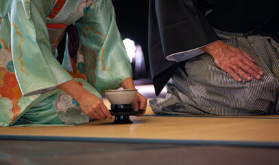 Japanese man and woman woman in traditional kimono, kneeling on Seiza position, during the tea...