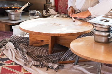 Turkish Food. Gozleme Turkish stuffed flatbread cooking process in traditional style. Flatten dough by rolling pin.