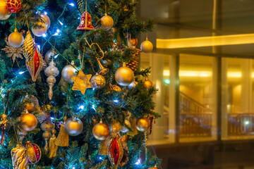 Many baubles on Christmas tree. Lights, spherical, star and other decorations are used to festoon the celebration.