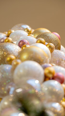 Christmas celebration concept. Bottom view close up photo of beautifully decorated yellow and white baubles and isolated on gold background with copyspace
