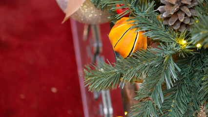 Christmas tree decorated with natural materials - slices of dried orange. On red background