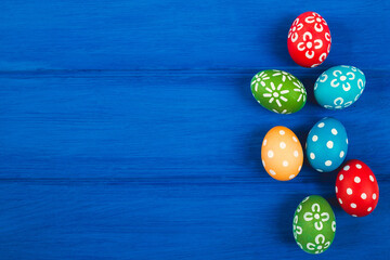 Colorful easter eggs on blue color wood background with space.