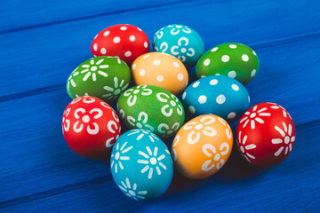 Colorful easter eggs on blue color wood background with space.