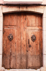 Old wooden door with wrought iron door knockers