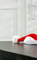 A minimalist table with a blank and a santa hat on a background of white doors in a Christmas day 