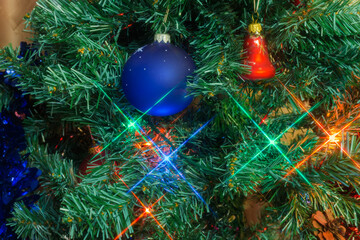Fragment of artificial Christmas tree with decorations and Christmas lights