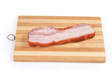 Piece of boiled smoked pork belly on wooden cutting board