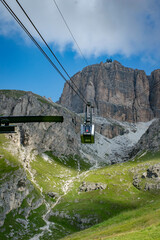 Fototapeta premium Dolomites, 2017, Selva di Val Gardena cable car cabin, mountains, green valley against the blue sky