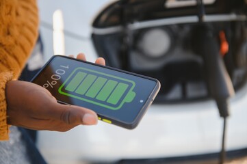 African American man charging his electric car.