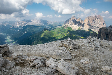 Dolomites, Italy, August 2018, view from the top of Passo Fedaia to the green valley and mountains in the distance