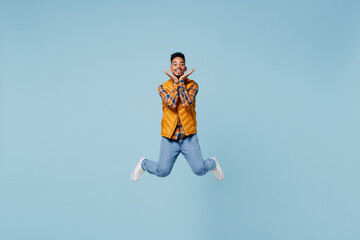 Fototapeta na wymiar Full size body length stunning delight fascinating young black man 20s years old wears yellow waistcoat shirt jump raised hand to face isolated on plain pastel light blue background studio portrait.