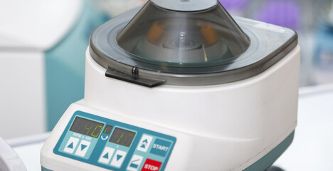 Close up of opened laboratory centrifuge with samples inside of rotating units used for separating liquids in lab for medical and scientific research.