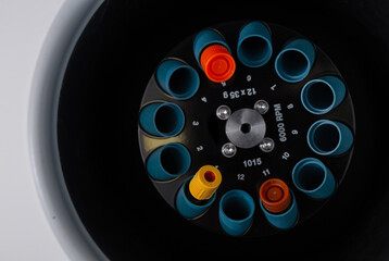 Close up of opened laboratory centrifuge with samples inside of rotating units used for separating liquids in lab for medical and scientific research.
