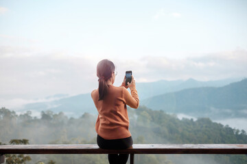 Happy tourist woman taking Photo by mobile smartphone, Blogger looking mountain view. Travel,...