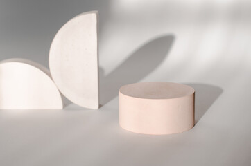Round plaster podium for advertising cosmetics on a gentle light background with beautiful shadows