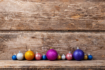 Border from multi-colored balls on a wooden background.