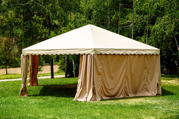 Beige canopy tent on green lawn garden © Roman