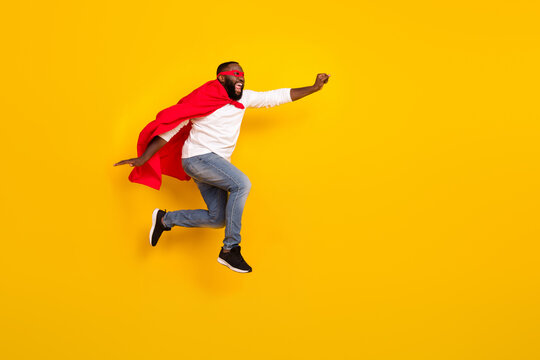 Full size profile photo of carefree strong hero raise fist empty space flight hurry isolated on yellow color background