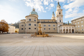 Fototapeta na wymiar Morning view on Residence Square with famous cathedral on background in Salzburg city. Traveling Austria, visiting famous landmarks concept