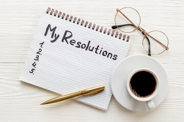 New Year resolution hand writing list - text on notepad, top view