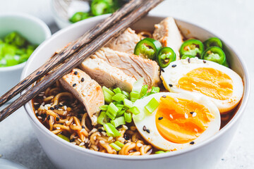 Asian noodle soup ramen with chicken and egg in gray bowl. Japanese food concept.