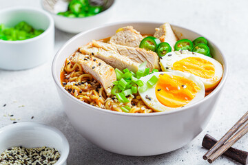 Asian noodle soup ramen with chicken and egg in gray bowl. Japanese food concept.